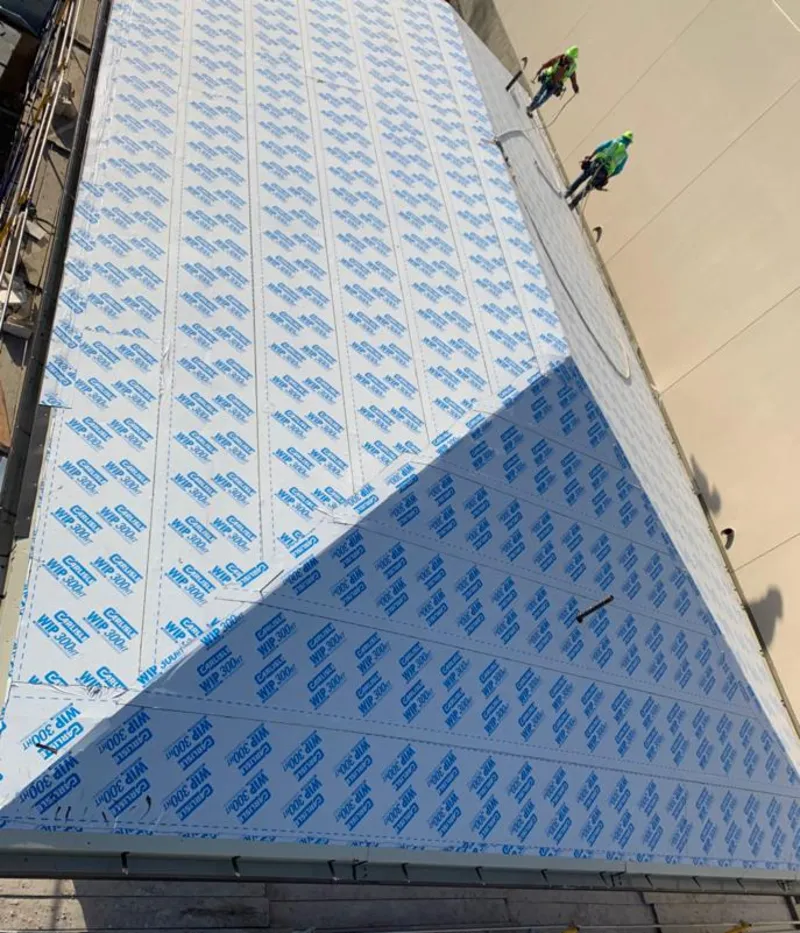 Professional roofers installing underlayment on a metal roof in Bowie